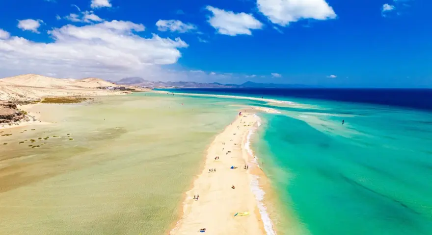 Plaża na Fuerteventurze, z turkusową wodą i piaszczystym cyplem, zachęca do wypoczynku. Czy to Fuerteventura czy Teneryfa, widok zapiera dech.
