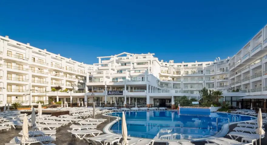 Idealna pogoda na Costa Brava: hotel z basenem i leżakami pod błękitnym niebem.