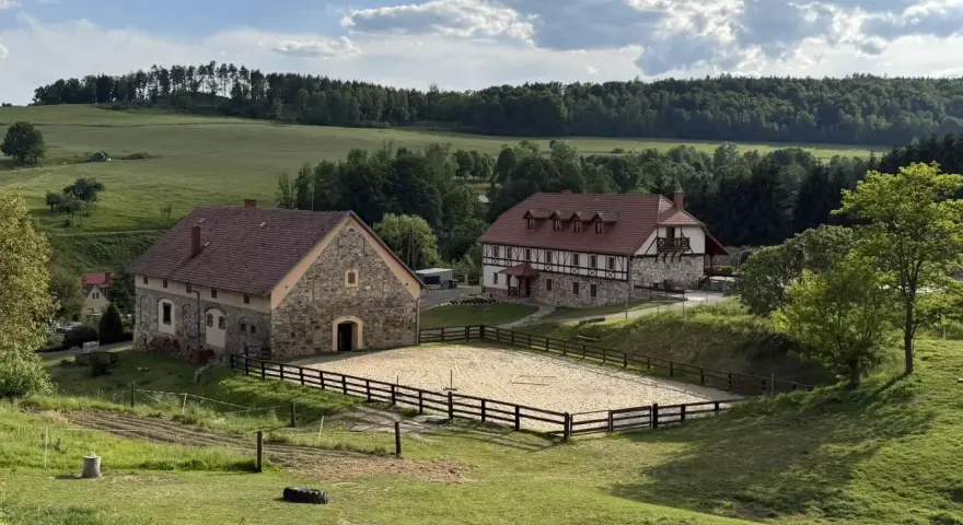 Malowniczy krajobraz z budynkami i ujeżdżalnią koni. Idealne miejsce na agroturystykę Dolny Śląsk.