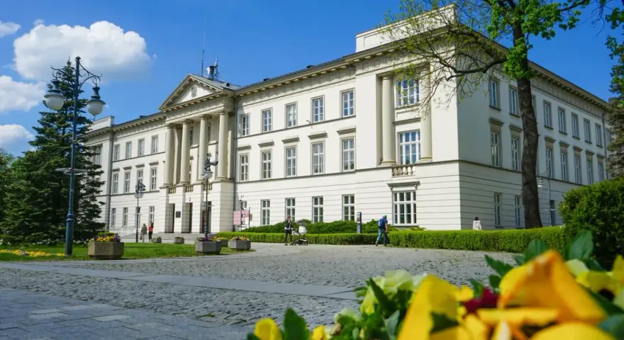 Biały budynek z kolumnami, otoczony zielenią, to jedna z radomskich atrakcji.