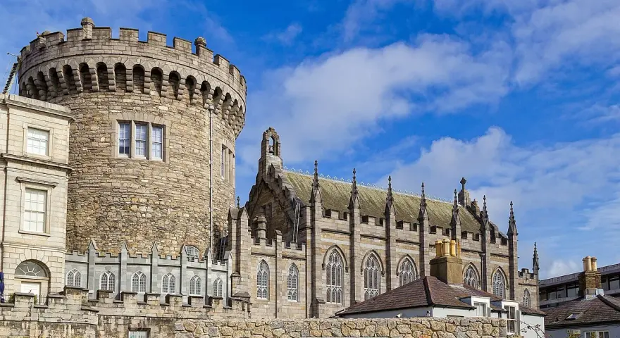 Kamienna wieża i gotycka katedra w Dublinie, stolicy Irlandii, pod błękitnym niebem.