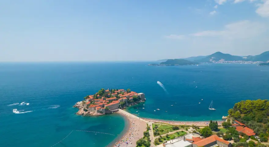 Wyspa Sveti Stefan, perła Czarnogóry, gdzie jechać na niezapomniane wakacje. Urokliwa plaża, turkusowe morze i malownicze widoki.