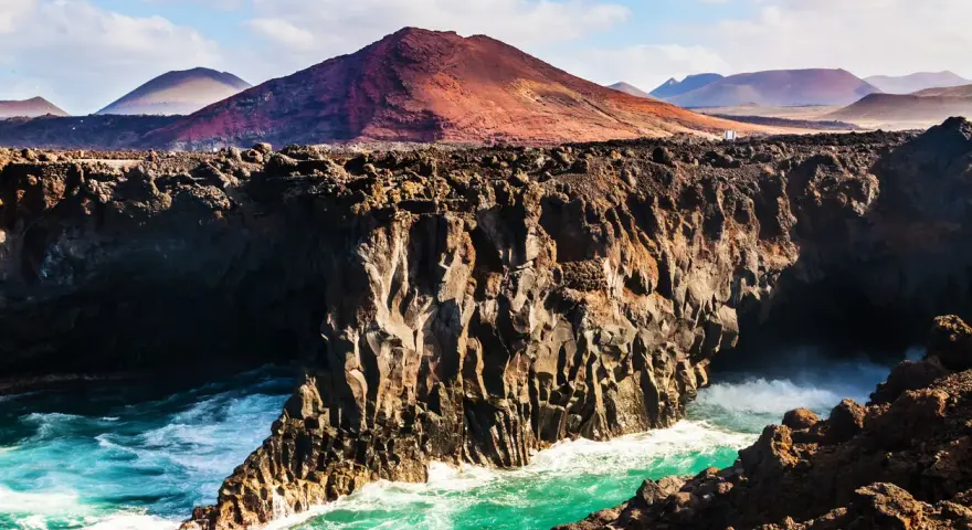 Wulkaniczne klify na Lanzarote, turkusowe morze i malownicze góry. Idealna pogoda na odkrywanie wyspy.