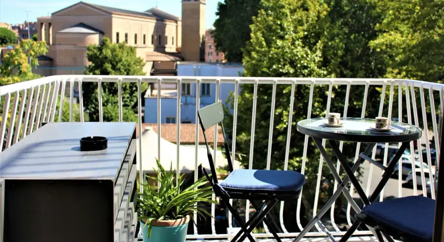 Balkon z widokiem na rzymskie dachy i kościół. Idealne miejsce, by zastanowić się, gdzie nocować w Rzymie.
