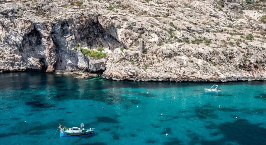 Malta, grudzień: turkusowa woda, skaliste klify i łodzie. Pogoda idealna na rejs.