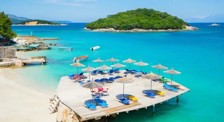 Rajskie albania plaże z turkusową wodą, leżakami i parasolami. Idealne miejsce na wakacje.