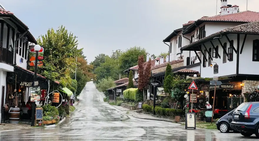 Ulica w Wielkim Tyrnowie po deszczu, z tradycyjną architekturą i sklepikami.