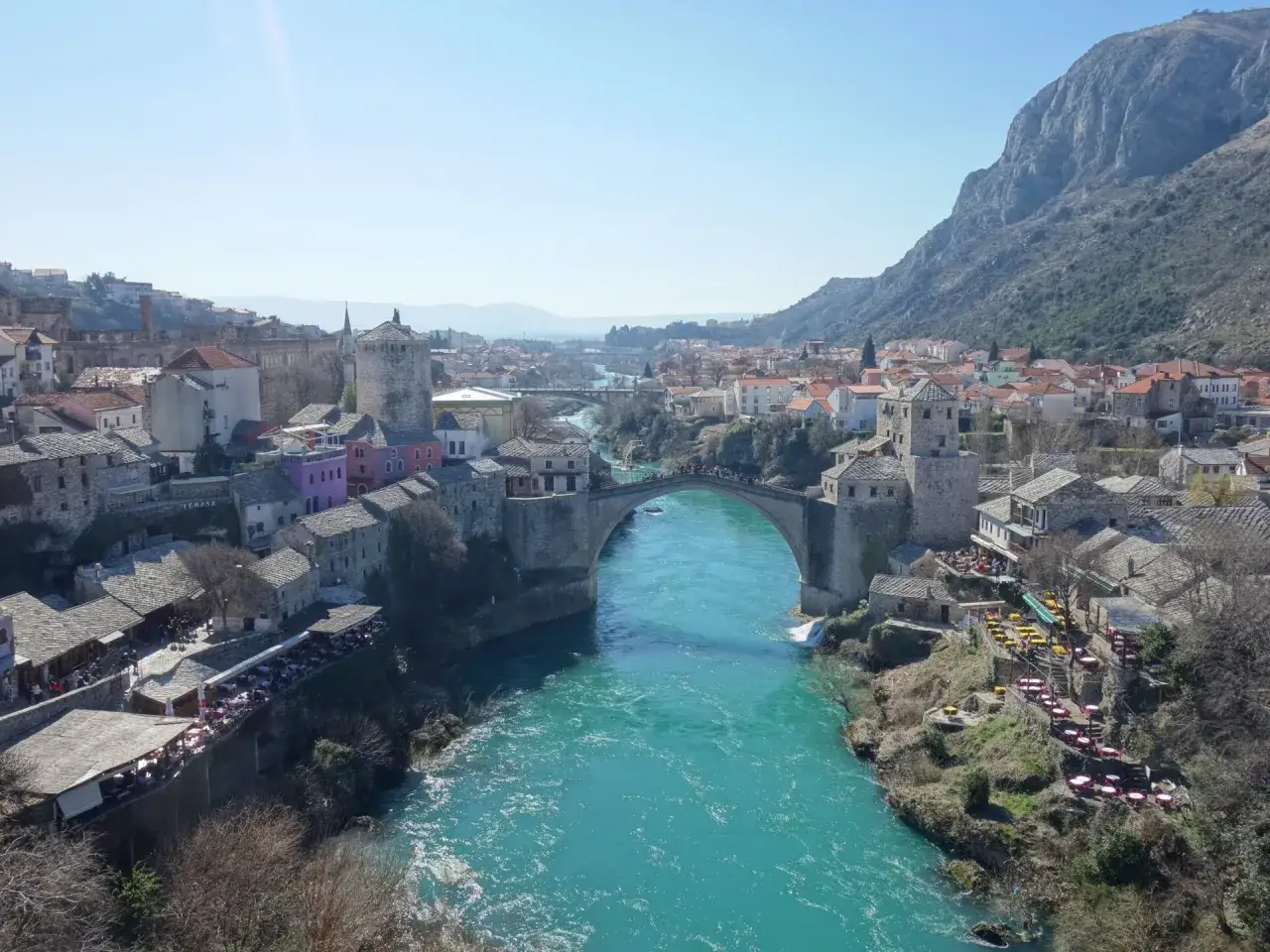 Mostar, Bośnia i Hercegowina: słynny Stary Most nad turkusową rzeką Neretwą, otoczony kamiennymi budynkami i górami.