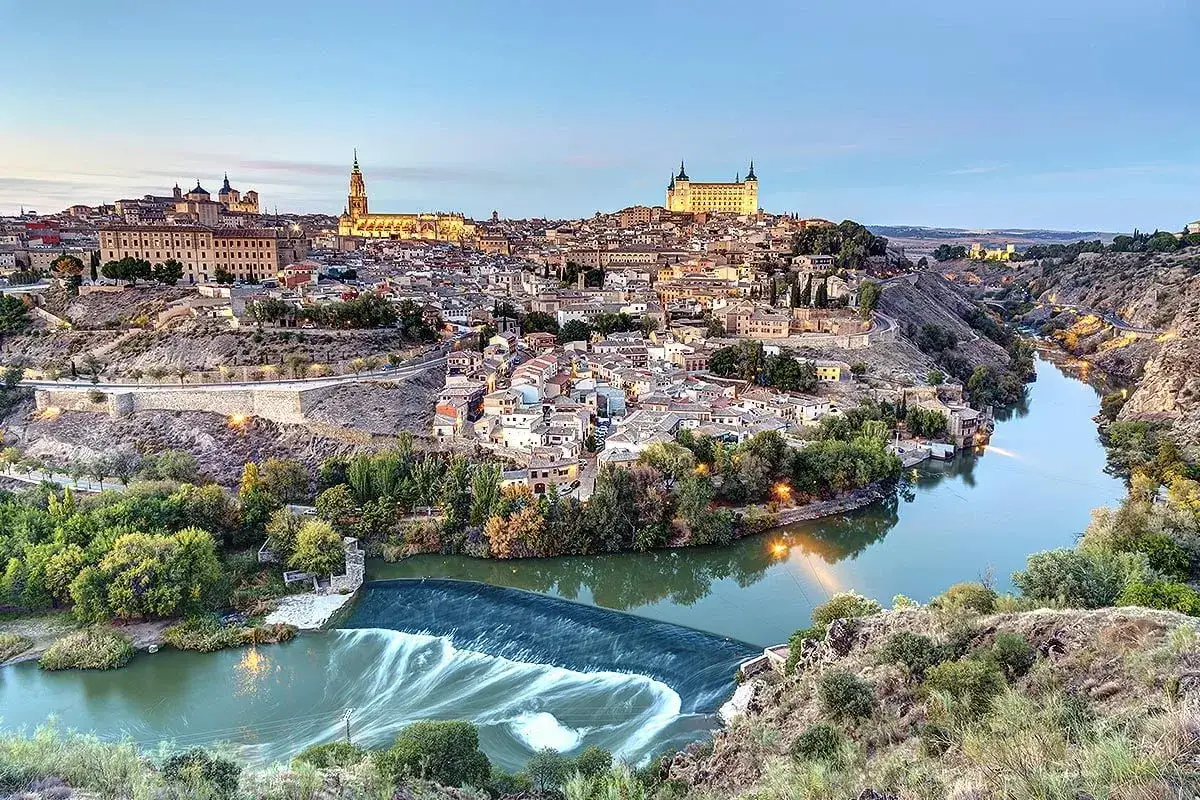 Widok na zabytkowe miasto Toledo w Hiszpanii, z rzeką Tag tworzącą malowniczy zakręt.