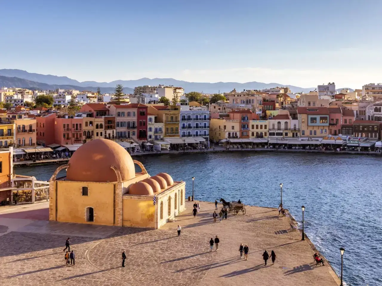 Malowniczy port w Chanii, Kreta. Atrakcje turystyczne, kolorowe kamienice i zabytkowa budowla z kopułą.