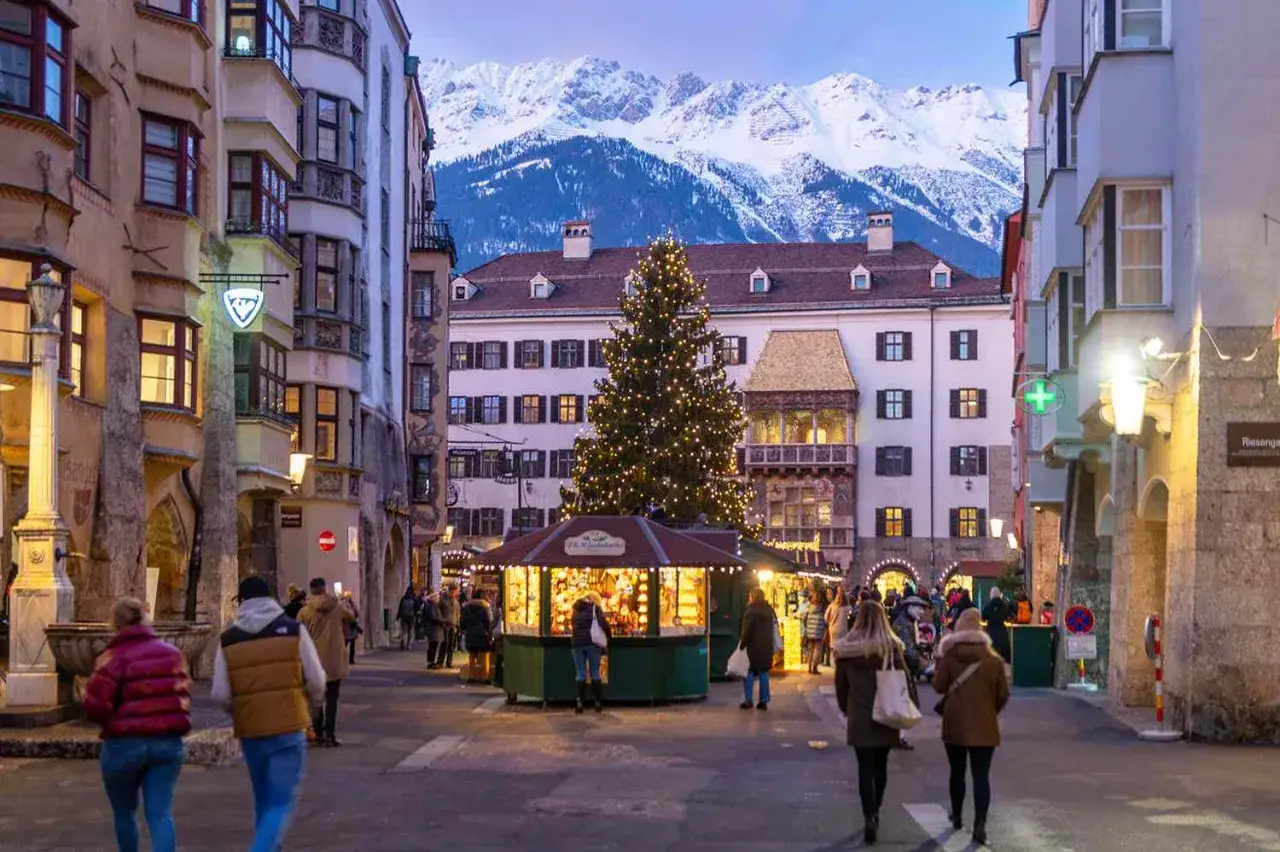 Świąteczny jarmark w Innsbrucku, gdzie na święta bożego narodzenia za granicę. Choinka i góry w tle tworzą magiczną atmosferę.
