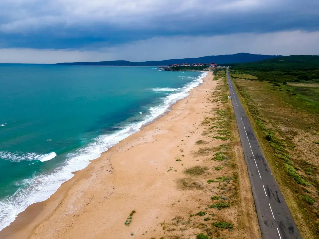 Piękne, turkusowe morze w Bułgarii. Pusta plaża i droga wzdłuż wybrzeża, idealne na wakacje.
