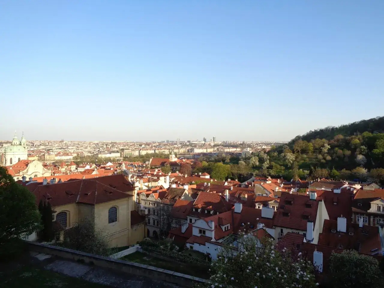 Widok na dachy Pragi z górującym nad nimi zamkiem na Hradczanach.